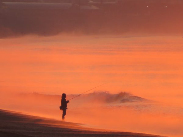 茅ヶ崎の海と空と江の島と烏帽子岩と富士山と日の出と釣り人の写真@2023/02/25